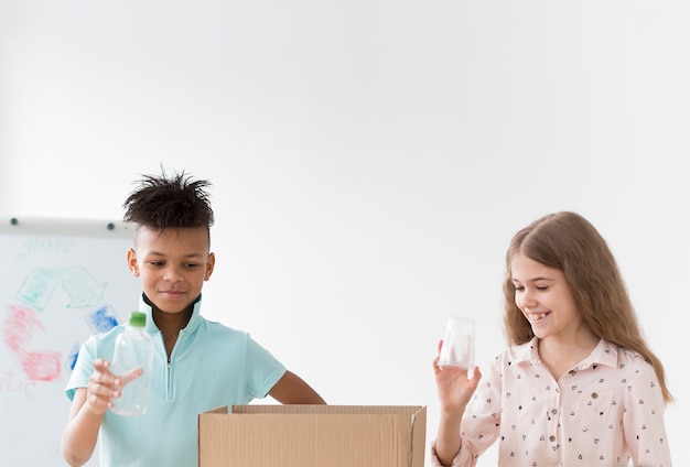 Nette kleine Kinder lernen, wie man recycelt