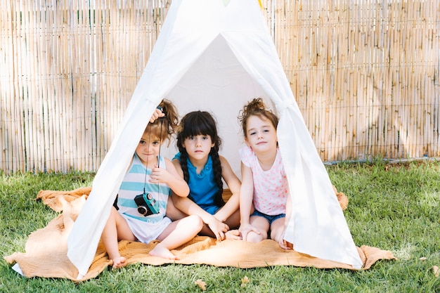 Nette Mädchen, die im Zelt sitzen