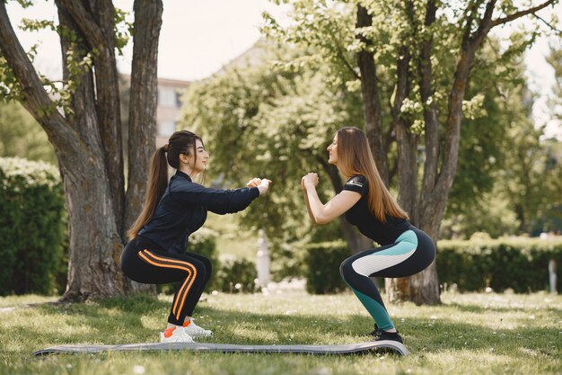 Nette Mädchen, die Yoga in einem Sommerpark tun