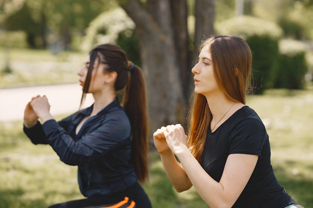 Nette Mädchen, die Yoga in einem Sommerpark tun