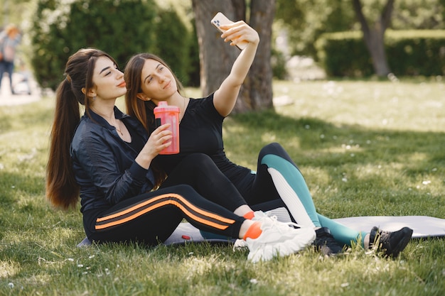 Nette Mädchen, die Yoga in einem Sommerpark tun