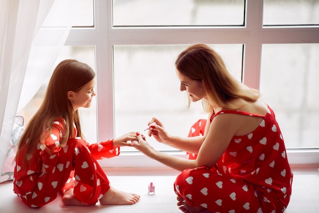 Nette Mutter und Tochter zu Hause in Pyjamas