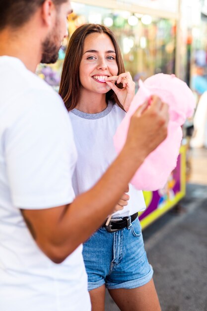 Nette Paare, die rosa Zuckerwatte genießen