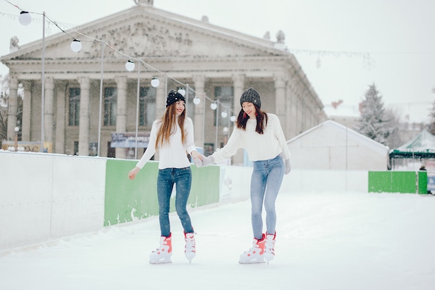 Nette und schöne Mädchen in einer weißen Strickjacke in einer Winterstadt