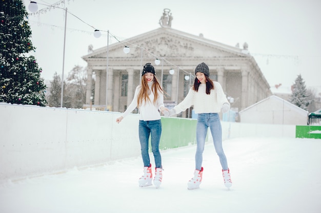 Nette und schöne Mädchen in einer weißen Strickjacke in einer Winterstadt
