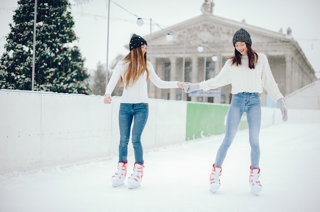 Nette und schöne Mädchen in einer weißen Strickjacke in einer Winterstadt