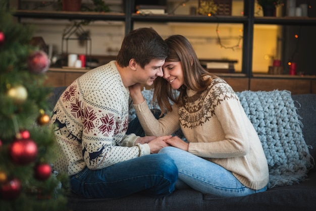 Kostenloses Foto nette weihnachtspaare auf couch