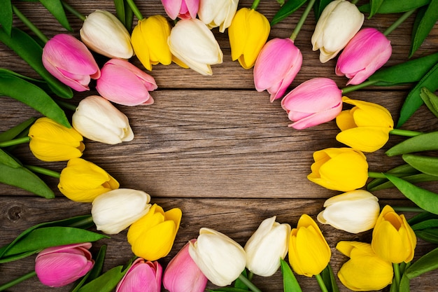 Nette Zusammensetzung mit farbigen Tulpen mit Kopienraum auf hölzernem