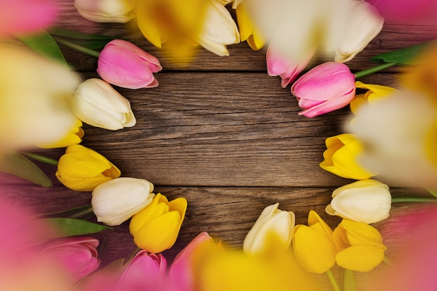 Nette Zusammensetzung mit farbigen Tulpen mit Kopienraum auf hölzernem