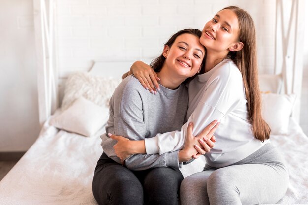 Netter blonder haltener Brunette im Schlafzimmer