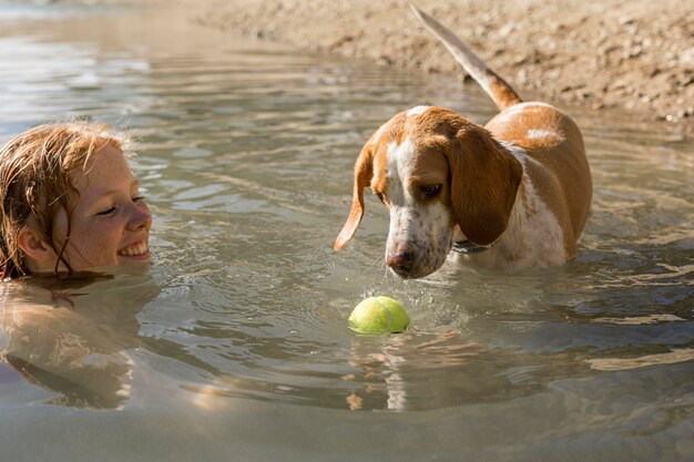 Netter Hund, der im Wasser steht und den Ball betrachtet