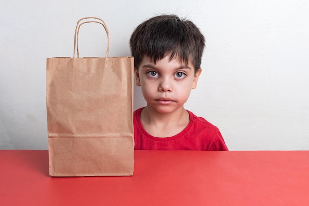 Netter junge, der fast-food-einkaufstasche hält