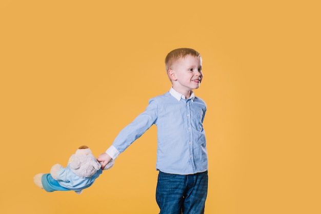 Kostenloses Foto netter junge, der mit teddybären geht