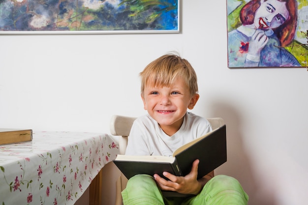 Netter Junge sitzt mit Buch