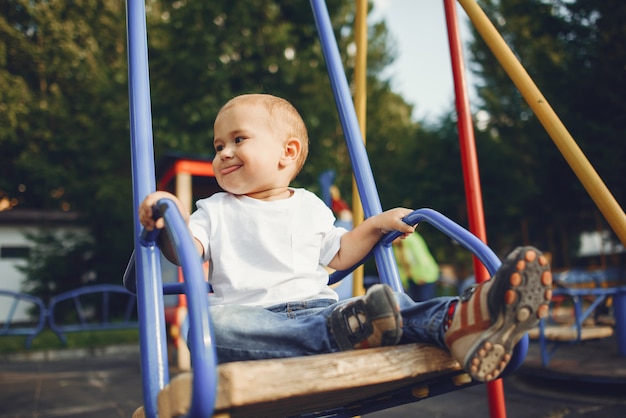 Netter kleiner Junge, der Spaß auf einem Spielplatz hat