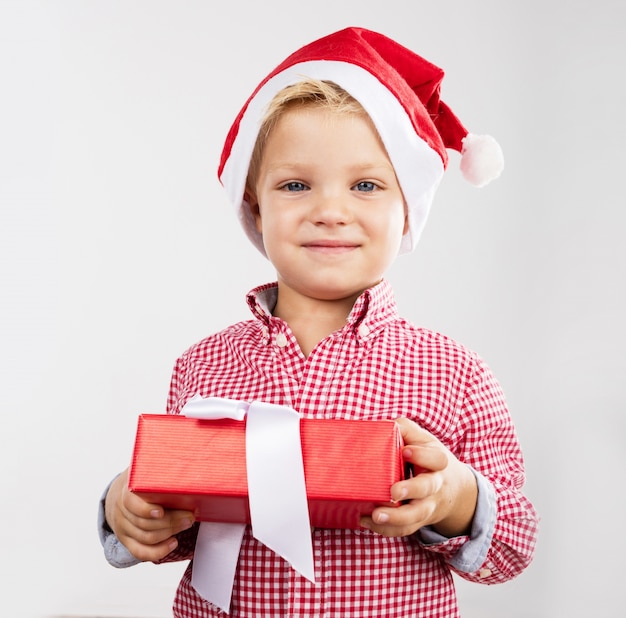 Netter kleiner Junge hält ein Geschenk