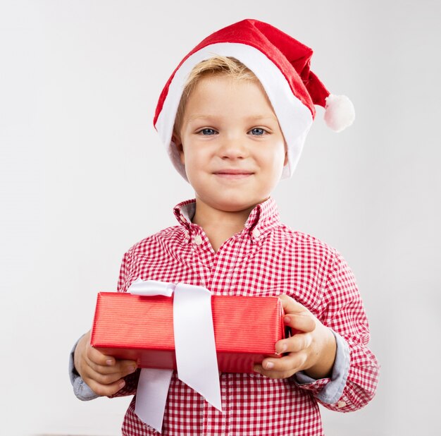 Netter kleiner Junge hält ein Geschenk