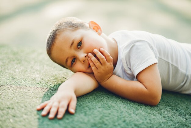 Netter kleiner Junge hat Spaß auf einem Spielplatz