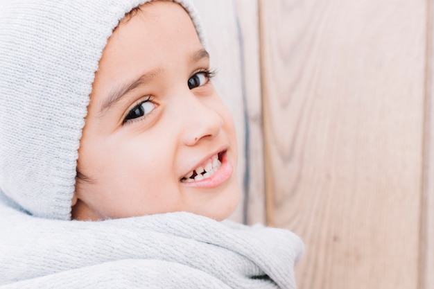 Netter kleiner Junge in der hellen Winterkleidung