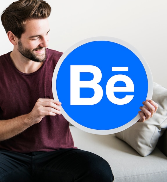 Netter Mann, der eine Behance-Ikone zeigt