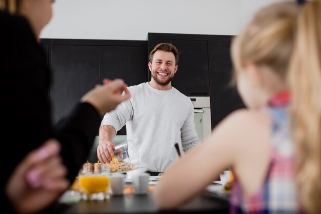 Netter Mann, der Frühstück für Familie vorbereitet