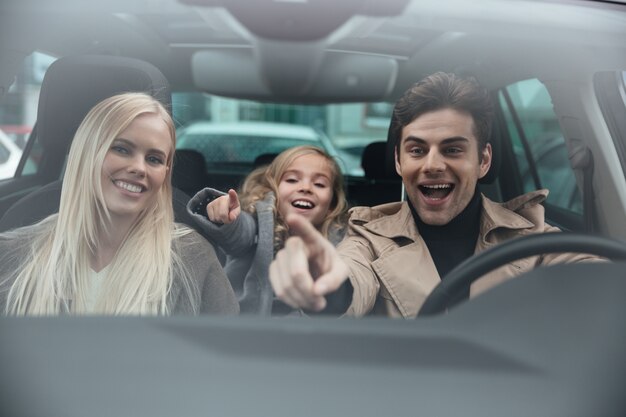 Netter Mann, der im Auto mit seiner Frau und Tochter sitzt