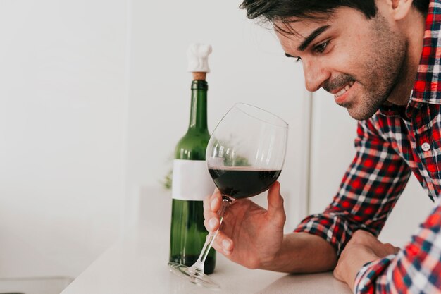 Netter Mann mit Wein bei Tisch