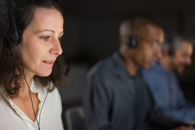 Netter reifer Call-Center-Betreiber, der Laptopschirm betrachtet