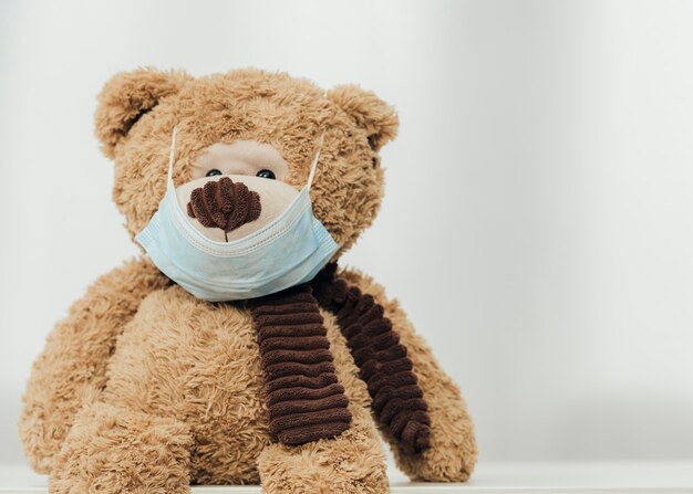 Netter Teddybär, der medizinische Maske trägt