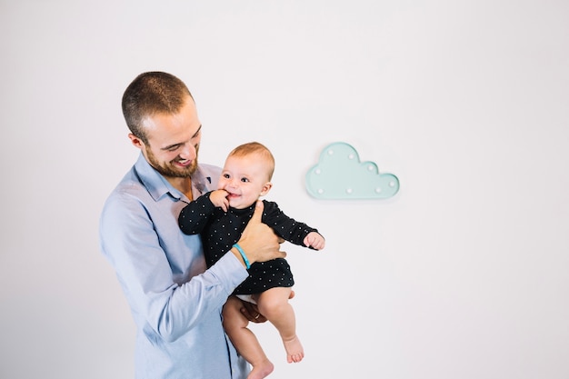 Netter Vater, der lächelndes Baby hält