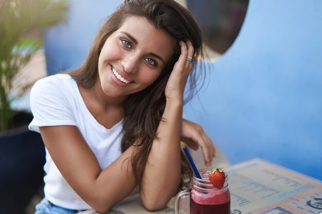 Nettes anziehendes junges hispanisches Brunettemädchen, das Haarkippen spielt