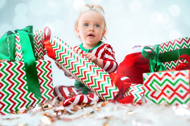 Kostenloses Foto nettes baby 1 jahr alt nahe weihnachtsmütze, die über weihnachten aufwirft