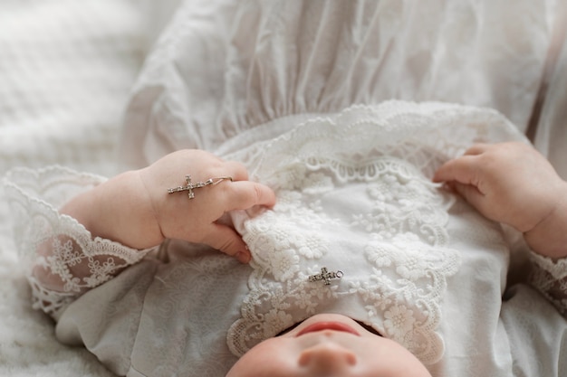 Nettes Baby des hohen Winkels, das Kreuz hält