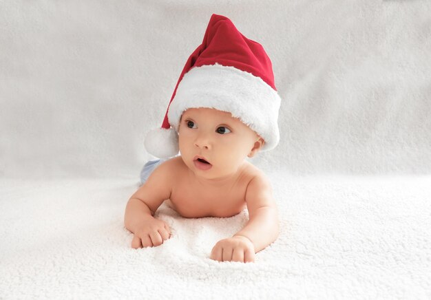 Nettes baby in weihnachtsmütze auf hellem hintergrund