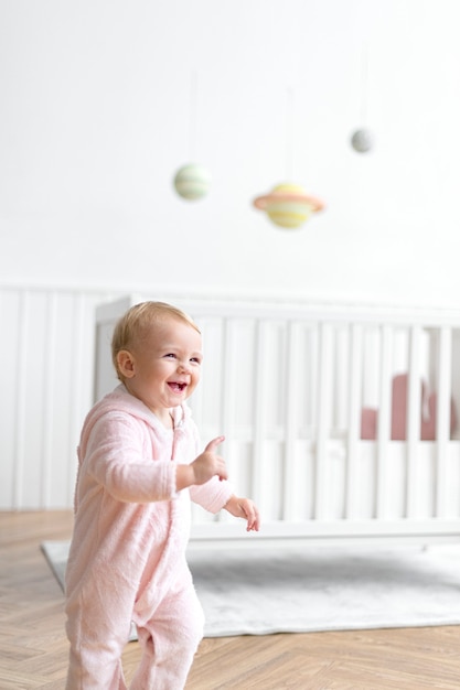 Nettes Babymädchen, das in ihrem Kinderzimmer lächelt