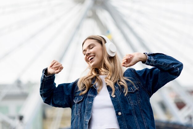 Nettes blondes Mädchen vor Riesenrad niedriger Ansicht