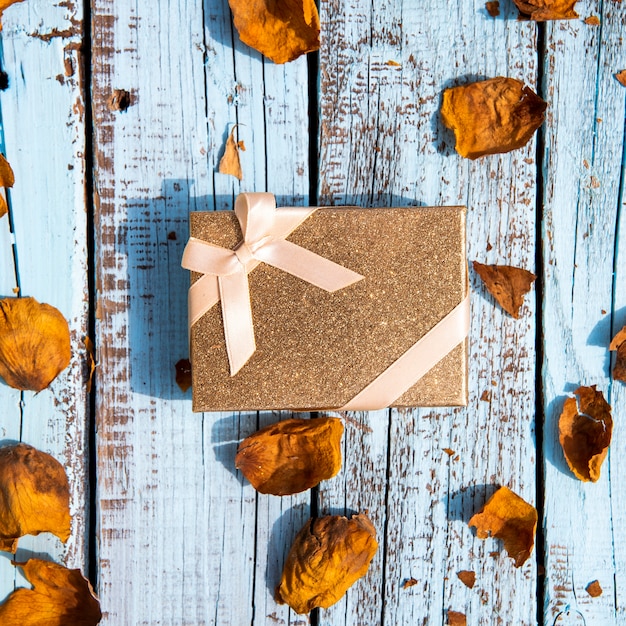 Nettes Geschenk umgeben durch getrocknete Blätter