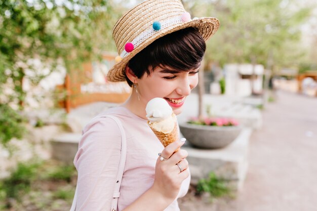 Nettes glückliches mädchen mit süßem eis in der hand, die zeit im freien verbringt und warmes wetter am wochenende genießt