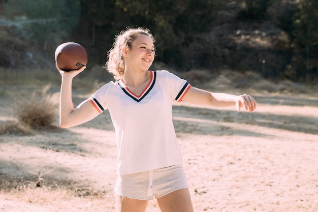 Nettes jugendlich Schulmädchen, das Rugby spielt