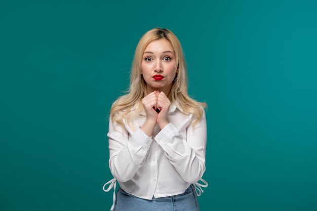 Nettes junges hübsches blondes Mädchen in einem weißen Hemd, das sehr aufgeregt ist und um einen Gefallen bittet