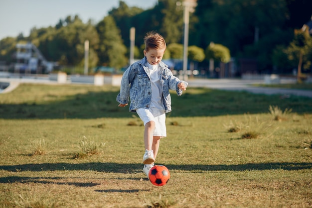 Nettes kleines Kind, das in einem Sommerpark spielt