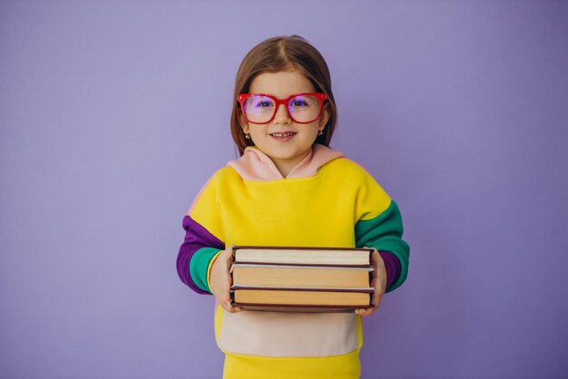 Nettes kleines Mädchen, das Bücher isoliert im Studio hält