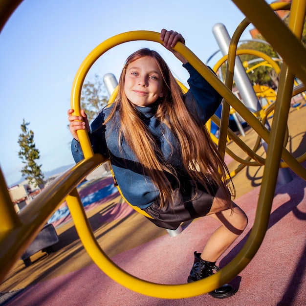 Kostenloses Foto nettes kleines mädchen, das spaß am spielplatz im freien hat