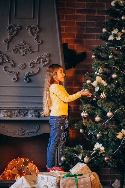 Nettes kleines Mädchen, das Weihnachtsbaum verziert