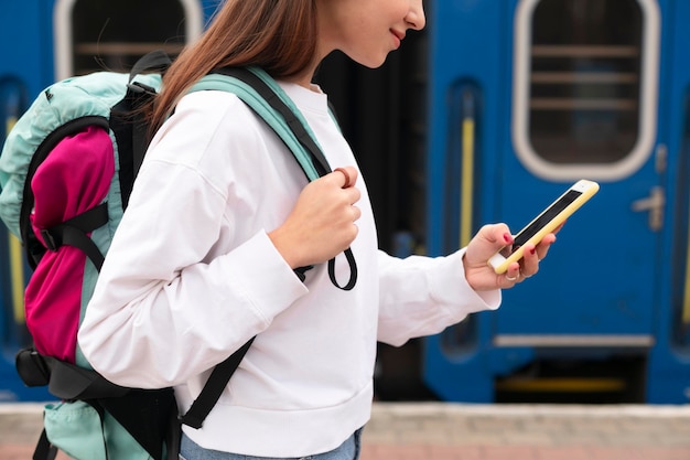 Nettes Mädchen am Bahnhof mit ihrem Smartphone