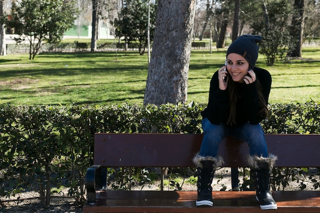 Kostenloses Foto nettes mädchen, das am telefon im park spricht