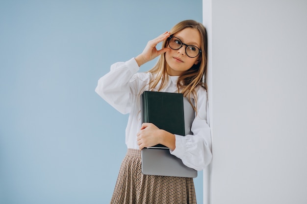 Nettes Mädchen, das Buch und Laptop im Büro hält