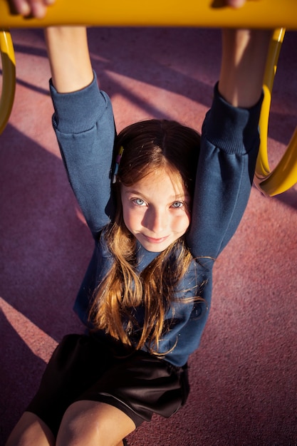 Nettes Mädchen, das Spaß am Spielplatz im Freien hat