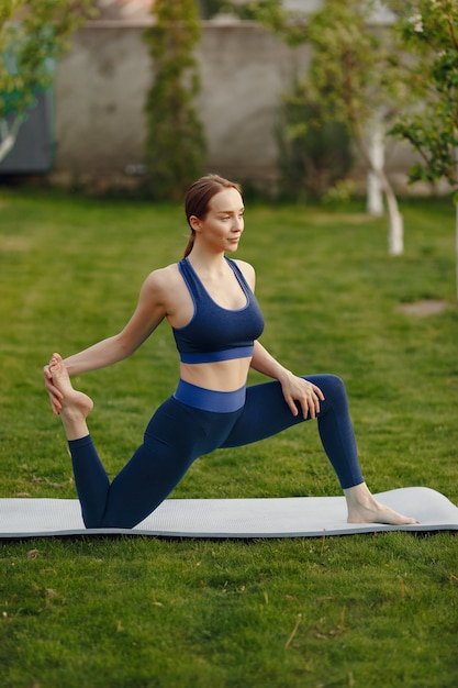 Nettes Mädchen, das Yoga in einem Sommerpark tut