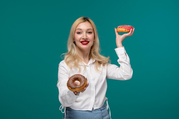 Nettes Mädchen junges entzückendes hübsches Mädchen in einem weißen ordentlichen Hemd mit Beeren- und Schokoladenkrapfen